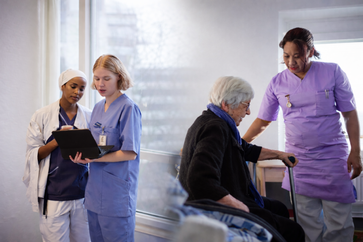 Vård och omsorgspersonal vårar en äldre krivvan