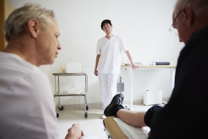 Patient i undersökningsrum med läkare och sköterska