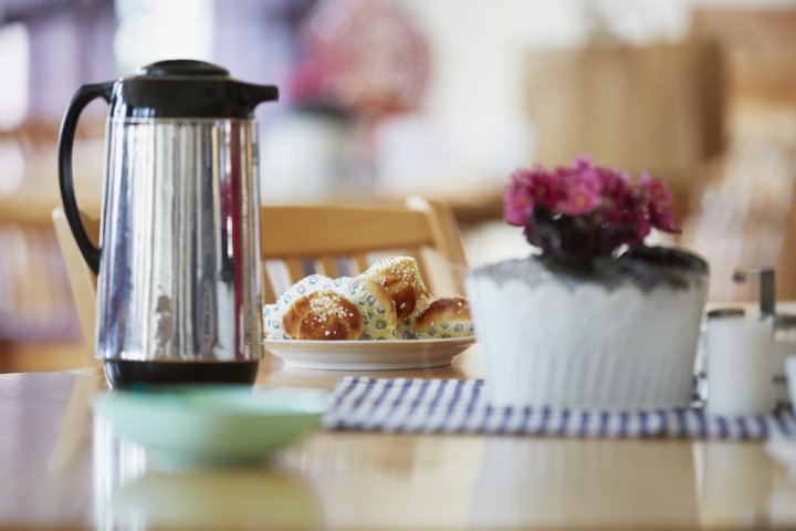 En tallrik med munkar på ett bord bredvid en kaffekanna